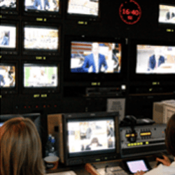 A photo of two people in a tv control room