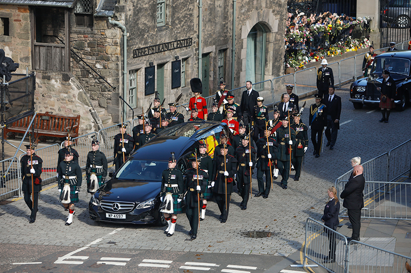 The cortege leaves the Palace of Holyroodhouse and makes its way past the Scottish Parliament on the way to St Giles' Cathedral.