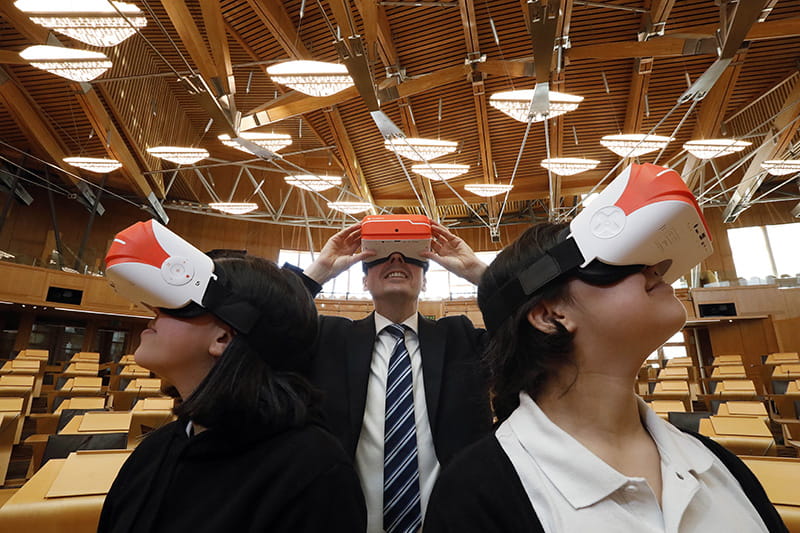 people in the debating chamber wear virtual reality headsets